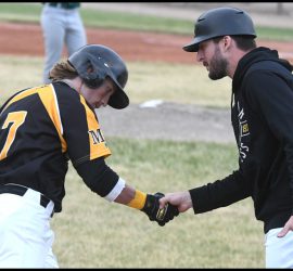 Michael Speck receives congratulations from coach Eric Marriott after his fourth-inning home run. Randy Palmer